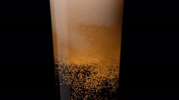 Close-up beer in glass. Bubbles rising. Slow Motion.