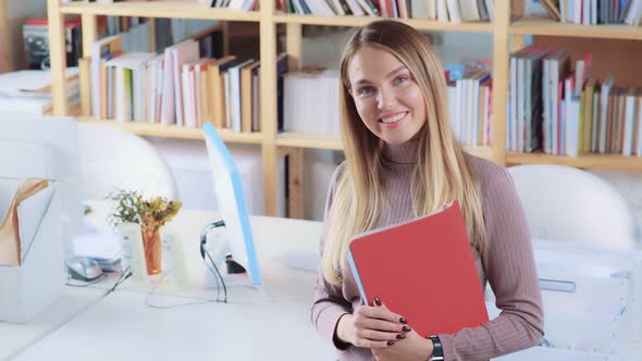 Office Worker with a Beautiful Smile Looks at Camera, Shot From Above