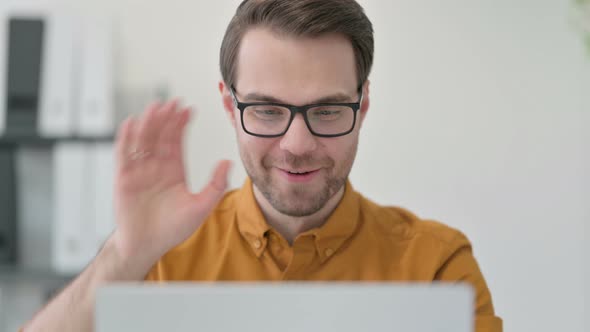 Close Up of Young Man with Laptop Celebrating in Office 