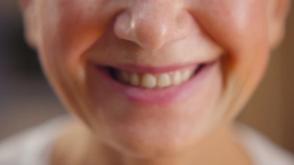 Close Up Portrait of Cheerful Mature Woman Smiling at Camera