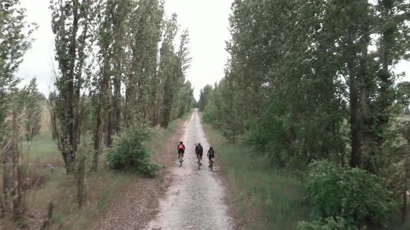 Cyclists riding on gravel bicycles on cobblestone road in countryside