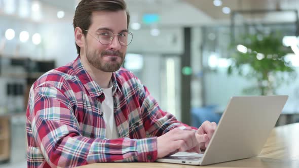 Serious Male Designer with Laptop Saying No By Head Shake 