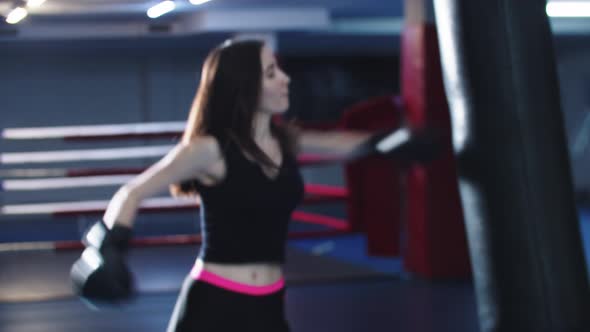 Young Woman Training Boxing Then Walks to a Camera and Shows Her Boxing Gloves