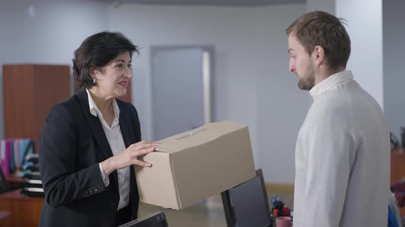 Portrait of Confident CEO Giving Cardboard Box Talking to Fired Employee and Leaving