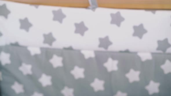 Mommy Rocks Wooden Cot with Cute Little Son in Light Room