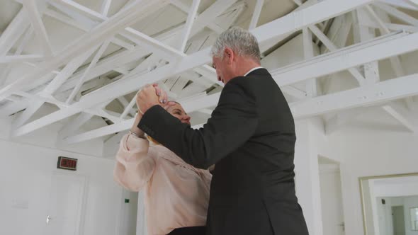 Caucasian senior couple spending time together dancing in a ballroom