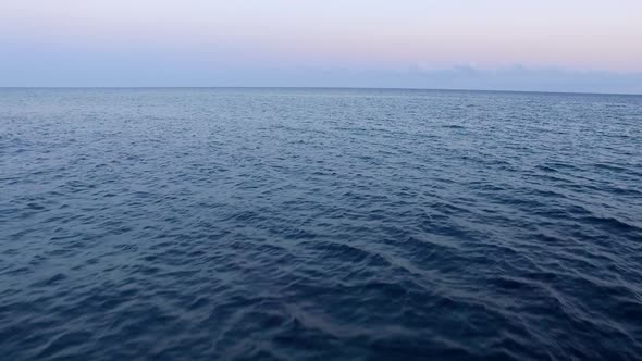 Sea aerial view. Sea waves at sunset with drone. Sunset over the ocean. Moving towards the horizon.