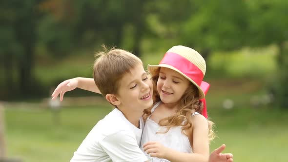 Little Boy Is Gently Hugging the Girl, They Are Happy and Carefree. Slow Motion