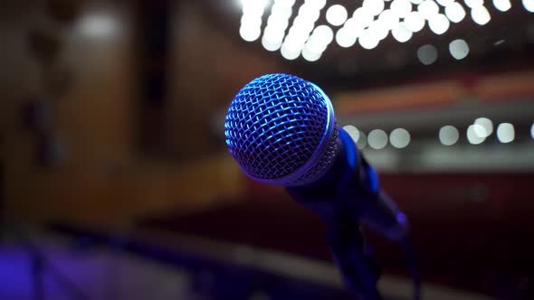 Close up View of microphone on stage facing empty auditorium in big concert hall
