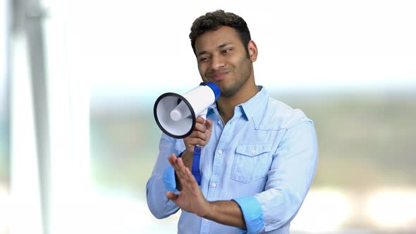 Indian Man with Megaphone on Blurred Background.