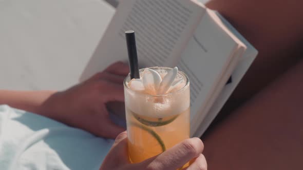 Woman Reading Book Sipping Cocktail