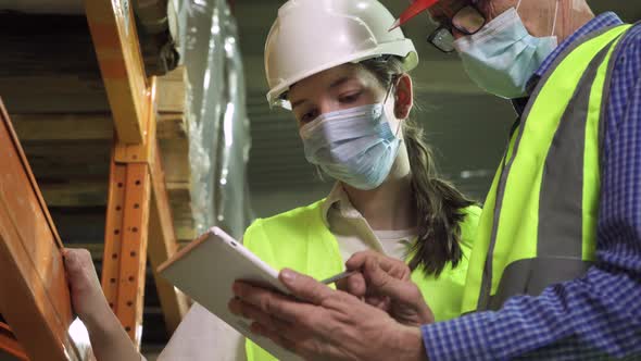 Female and Male Engineers Wear Safety Helmets in the Storage Room