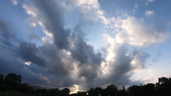 Beautiful sunset with sun rays shining through the clouds. Time lapse alt