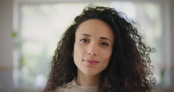 A woman with curly hair smiling