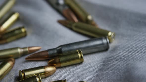 Cinematic rotating shot of bullets on a fabric surface - BULLETS 097