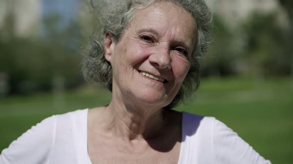 Cheerful Grey Haired Old Lady Posing in City Park