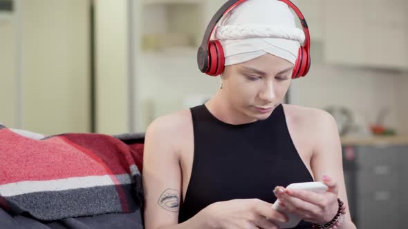 Middle Shot of Absorbed Young Caucasian Woman in Headphones Listening To Playlist Music and