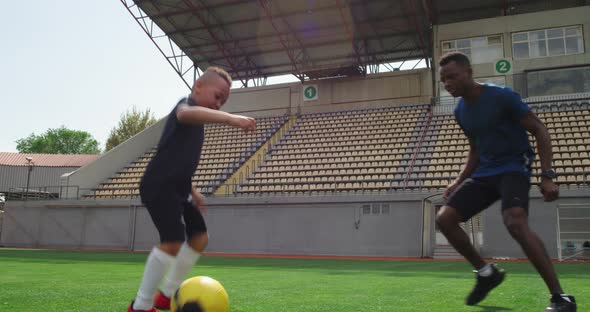 Diverse Father and Son Playing Football on Stadium