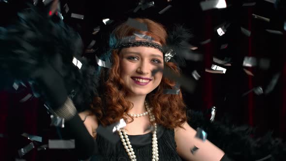 Excited Retro Styled Woman Dressed in Roaring Twenties Era Dancing and Smiling Under Confetti Rain