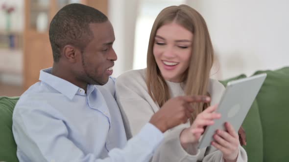 Loving Mixed Race Couple Using Tablet Together at Home