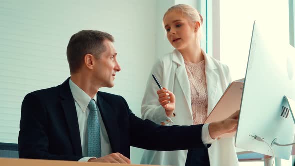 Two Business People Talk Project Strategy at Office