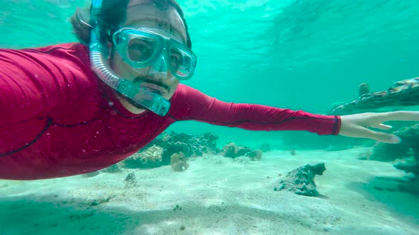 Man in an Underwater Mask is Snorkeling in Clear Water