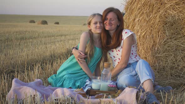 Mother And Daughter On A Picnic In A Wheat Field