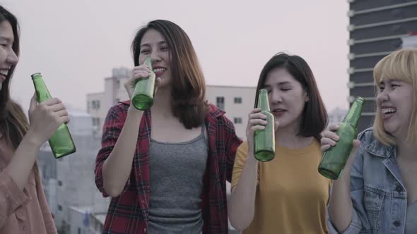 Group of young asian people dancing and raising their arms up played sunset on rooftop hanging out.