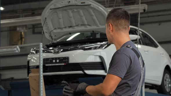 Cheerful Mechanic Putting on His Gloves Smiling To the Camera