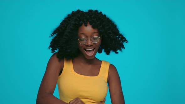 African Woman Dancing Actively Over Yellow Background