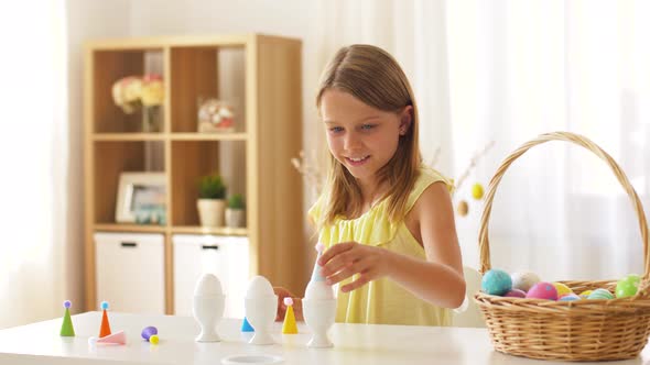 Happy Girl Decorating Easter Eggs at Home 