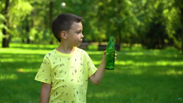 Boy drinking water from a bottle in the park