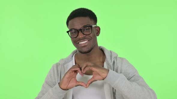 African Man Showing Heart Shape By Hands on Green Background