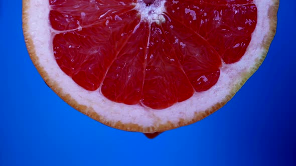 Quench Thirst in Summer Heat Closeup View of Juicy Slice of Red Grapefruit in Blue Background