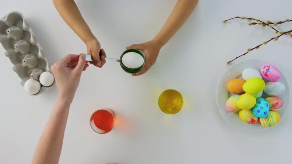 Hands of Child and Parent Dyeing Easter Eggs