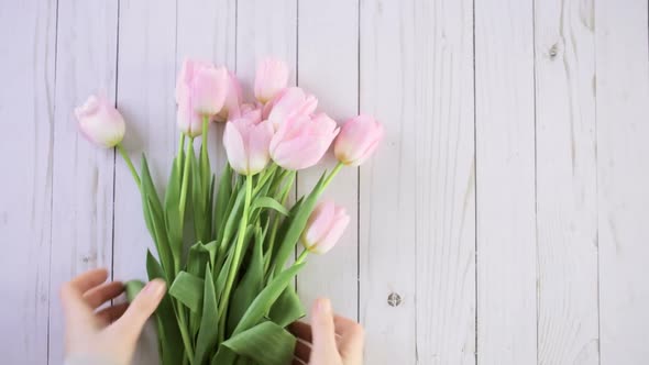 Bouquet of pink tulips on a wood background.