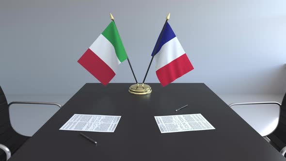 Flags of Italy and France and Papers on the Table