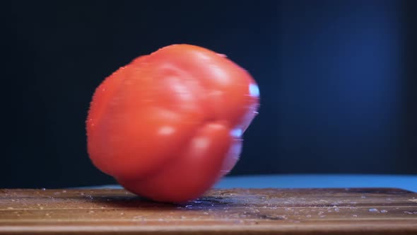 Wet Bell Pepper of Red Colour Spins on Brown Wooden Board