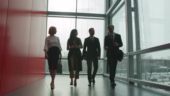 Dolly Shot of Businesspeople Female and Male Walking in Office Center Hall Talking