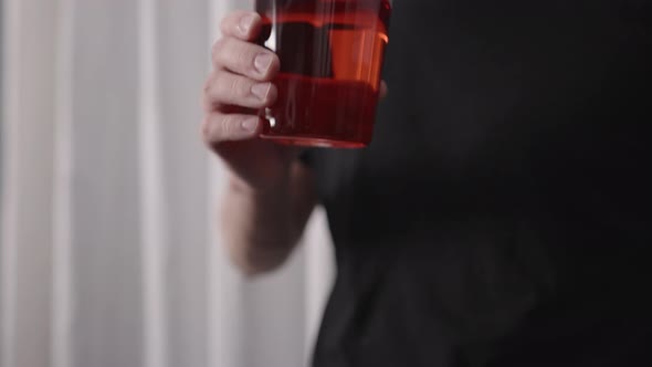Slow Motion Man Drinking Red Drink From Tumbler Glass Near Window