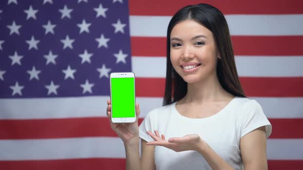 Girl Showing Smartphone With Green Screen, US Flag on Background, Translator App
