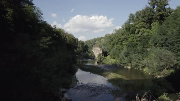 -SHOT: through, Sam Kolder-DESCRIPTION: drone video over the Fiora river passing between a bridge v