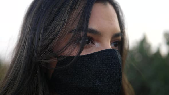 A beautiful young hispanic woman wearing a reusable cloth respiratory face mask to prevent infection