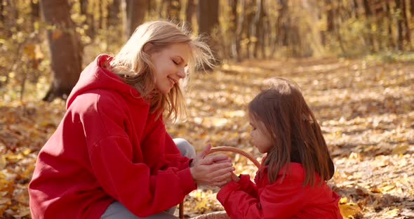 Mother and Daughter Sat Down in an Autumn Forest