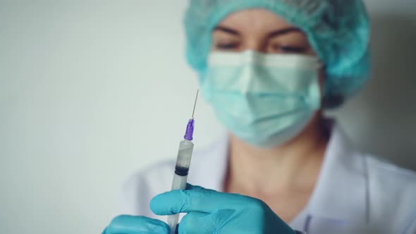 Woman Doctor Preparing Syringe for Injection