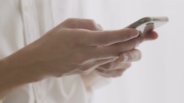 Close up hands handsome man using smartphone typing message chatting with friends.