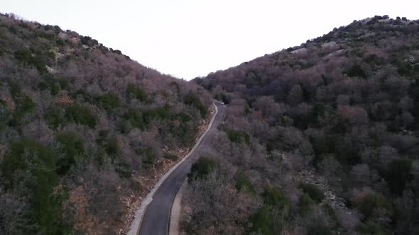 Flying over a high mountain valley road with dry earth and  vegetation. Location is Mt, Hermon in th