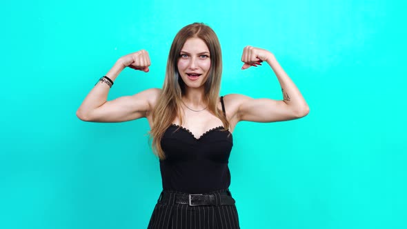 Portrait of a Young Woman Showing Her Muscles Smiling at the Camera