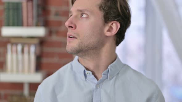 Upset Portrait of Young Man Looking Around 