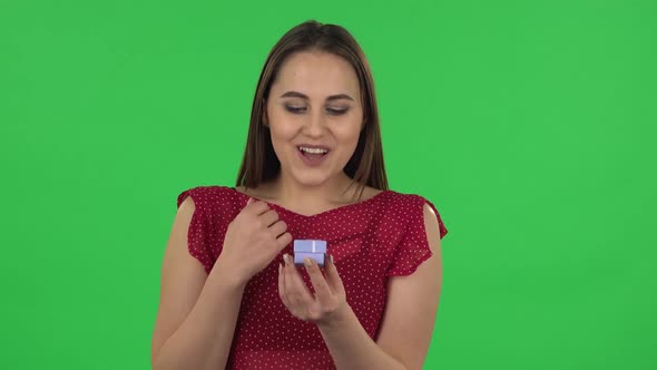 Portrait of Tender Girl Is Opening a Small Box with a Surprise and Is Very Rejoicing, Saying Yes